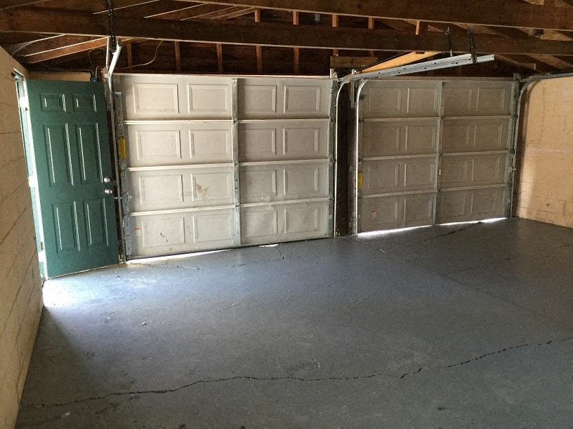 a garage with a green door and a concrete floor