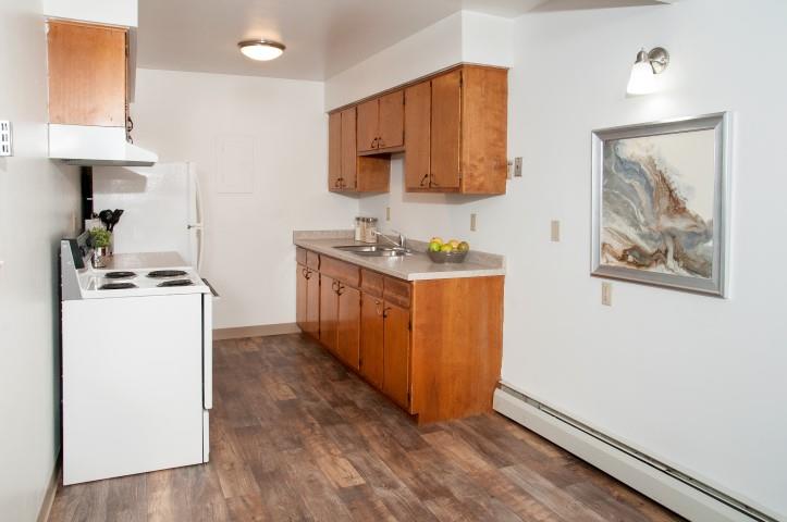 Bright Kitchen at 8920 Wentworth Apartmetns with White Walls and Dark Wood Floors