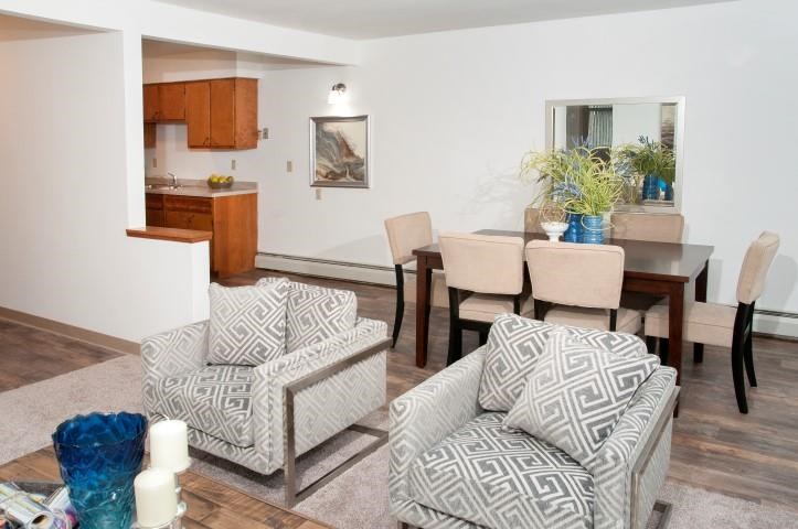 a living room and dining room with a table and chairs