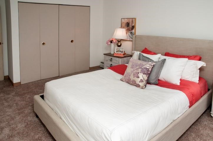 a bedroom with a white bed and red pillows