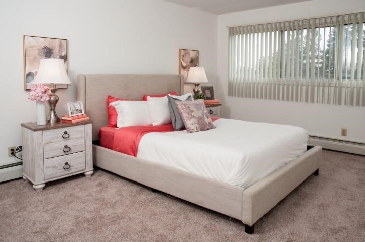 a bedroom with a bed and a night stand