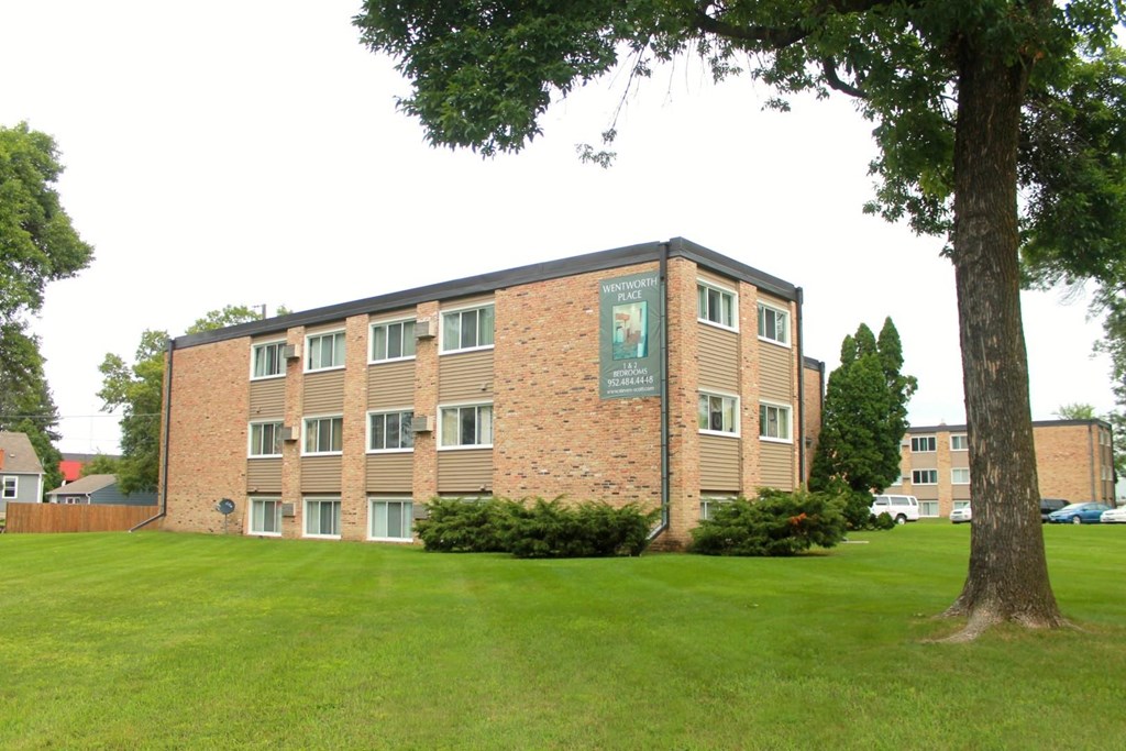 a brick building with a tree in front of it