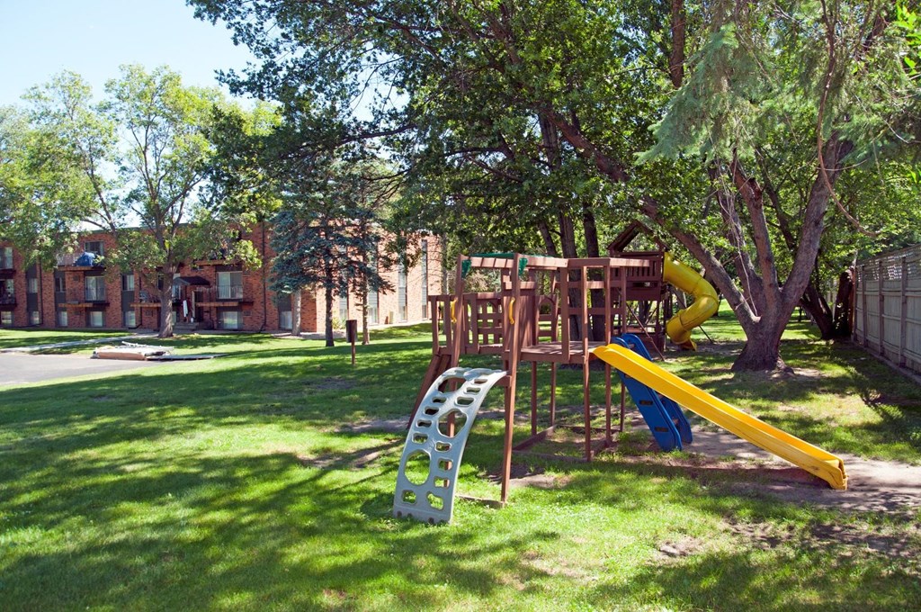 a playground with a playset and a slide in a park