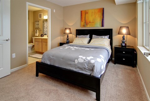 a bedroom with a bed and a bathroom with a sink