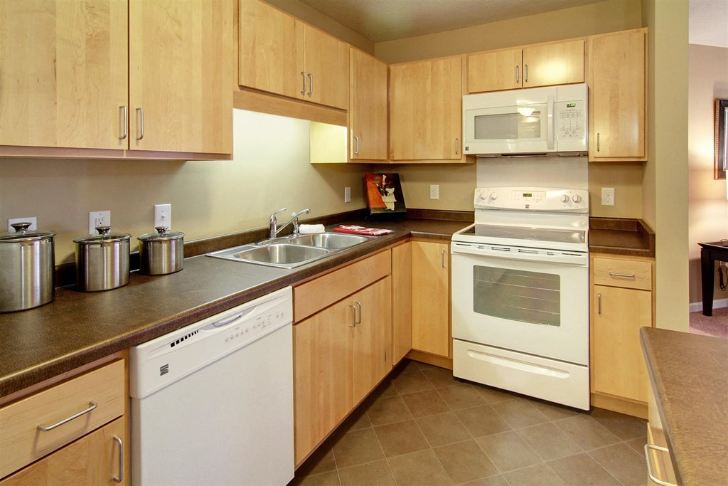 a kitchen with white appliances and wooden cabinets
