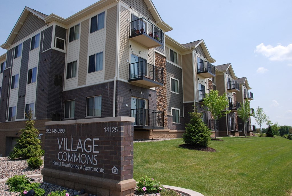 an apartment building with a sign that reads village commons
