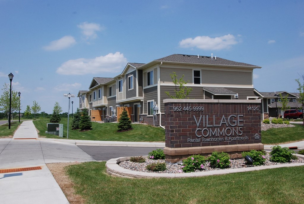 a sign that reads village commons in front of some houses