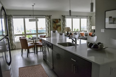 A modern kitchen with a large island and a dining table with chairs.