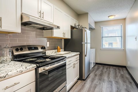 a kitchen with stainless steel appliances and white cabinets