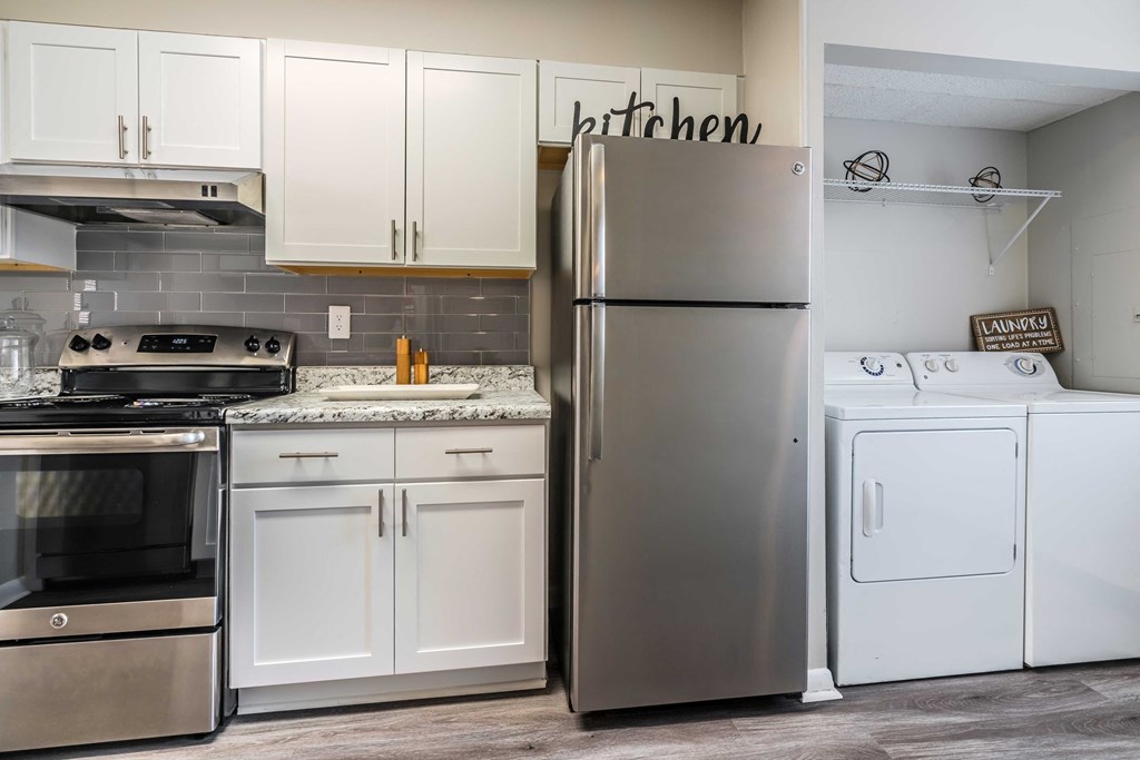 a kitchen with stainless steel appliances and white cabinets