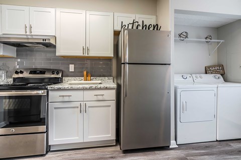 a kitchen with stainless steel appliances and white cabinets