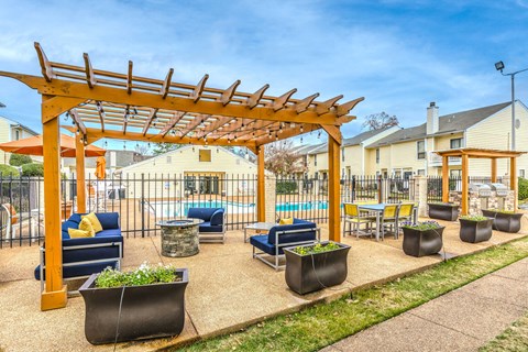 a patio with a pergola and a pool with chairs and tables