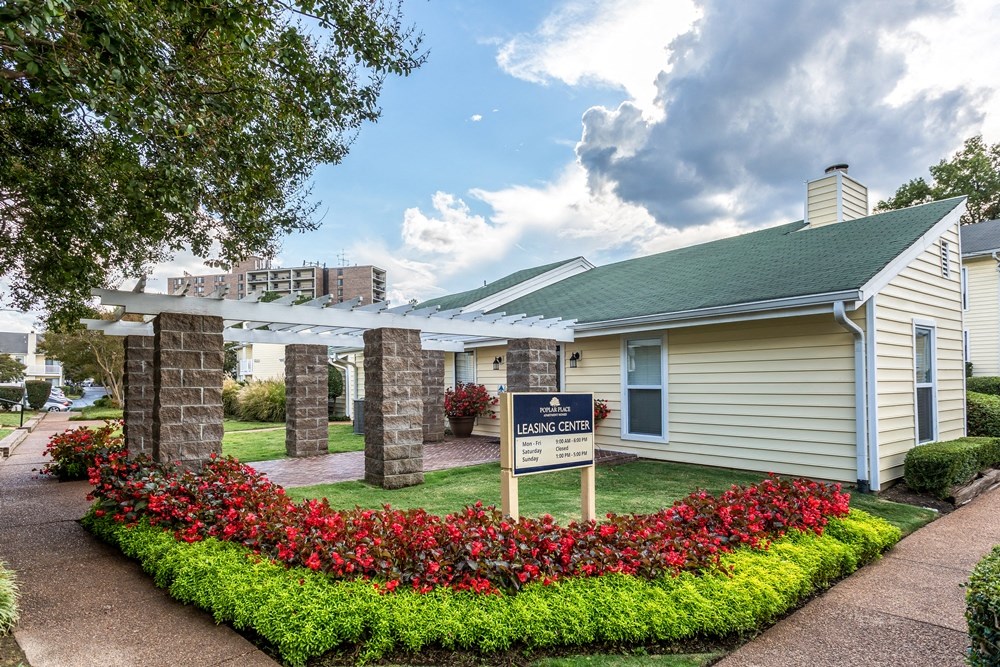 a small white building with a sign in front of it