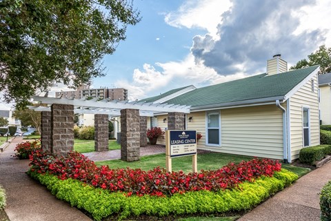 a small white building with a sign in front of it