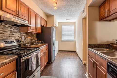 an empty kitchen with wood cabinets and stainless steel appliances