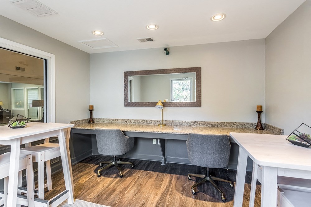 a dryer room with two desks and chairs and a mirror