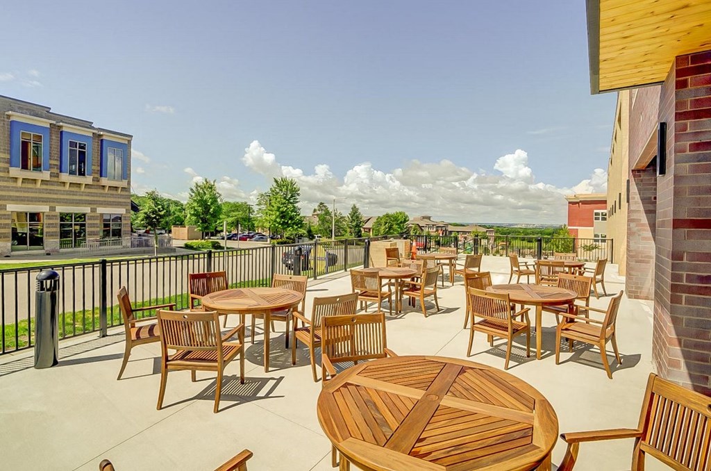 a patio with tables and chairs on top of a building