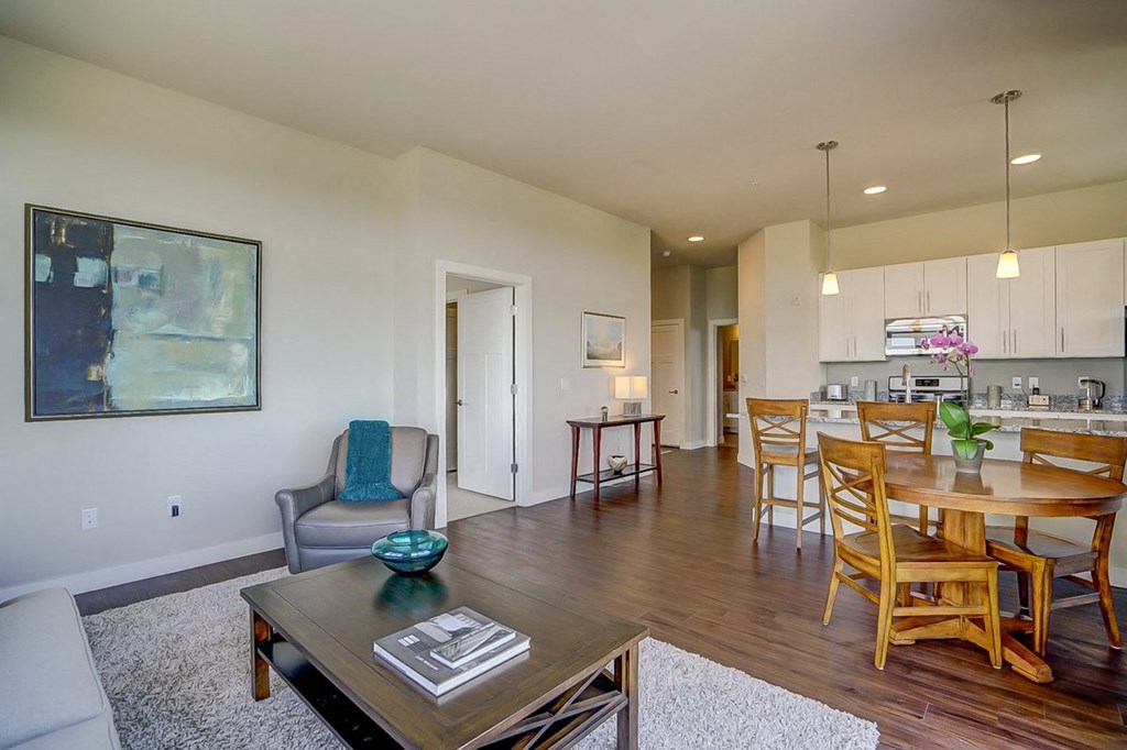 a living room and dining room with a table and chairs
