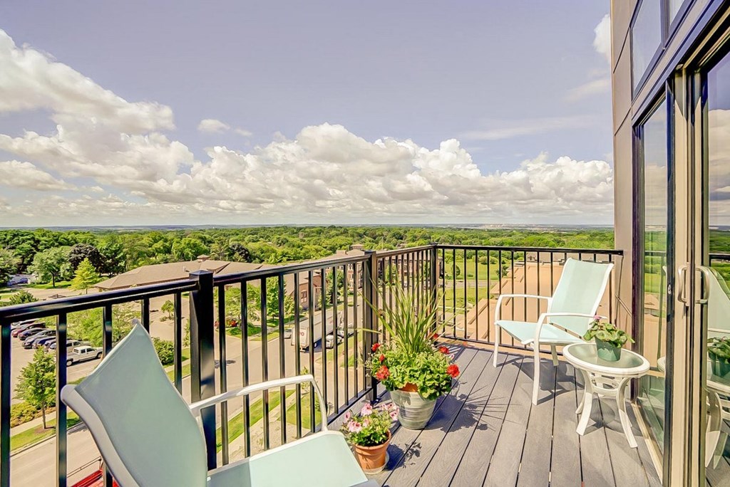 a balcony with two chairs and a view of the ocean