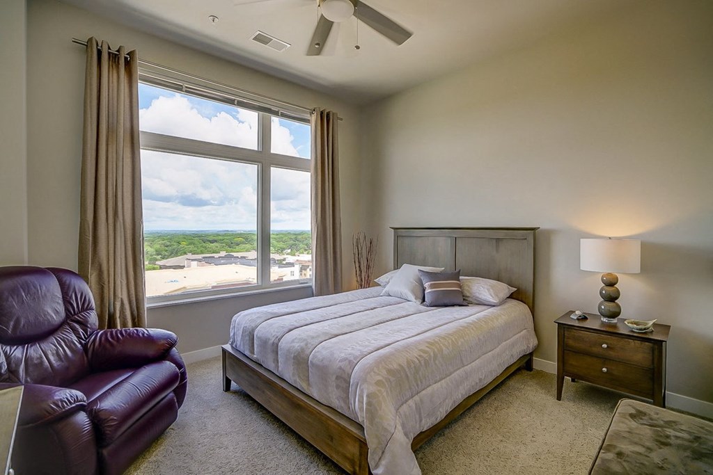 a bedroom with a large window and a bed
