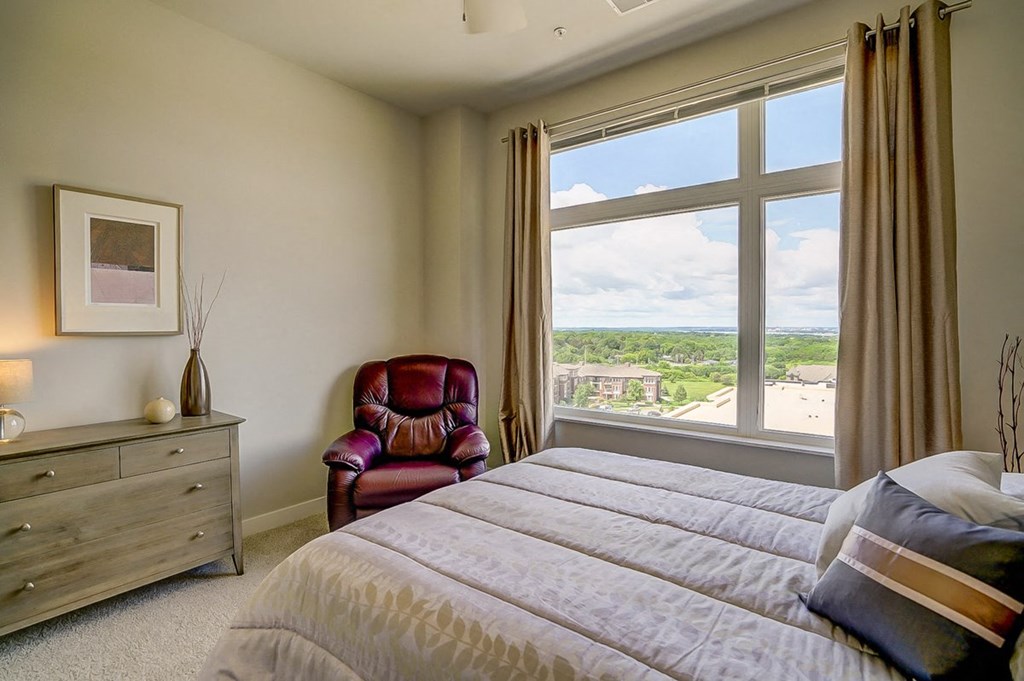 a bedroom with a large window and a bed