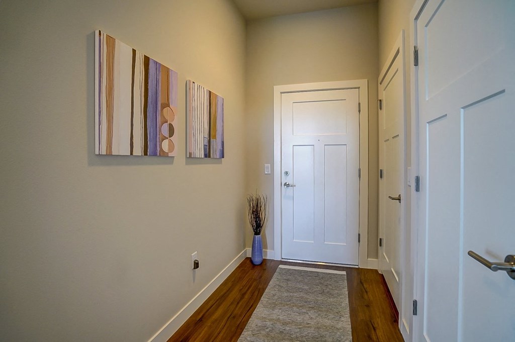 a hallway with a door and a painting on the wall