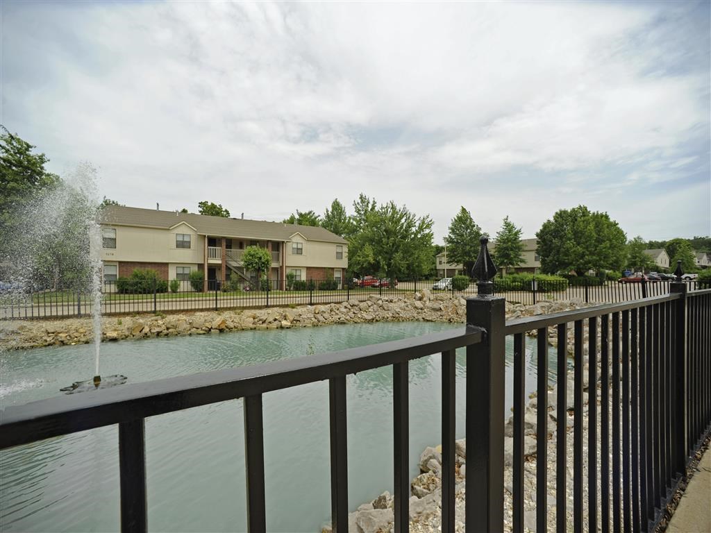 a pond in front of a building with a fountain