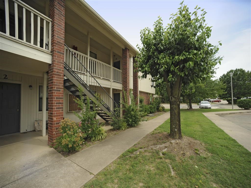 a building with stairs and a tree in front of it