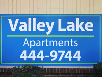 a sign for valley lake apartments on the side of a building
