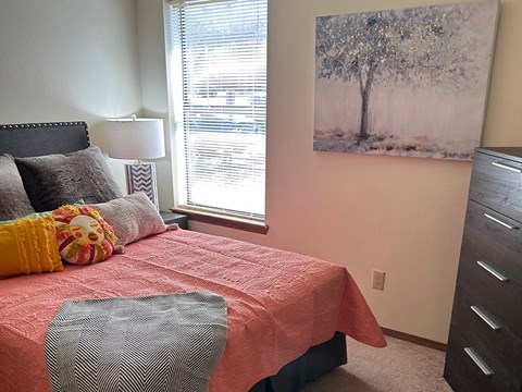 a bedroom with a bed and a painting on the wall