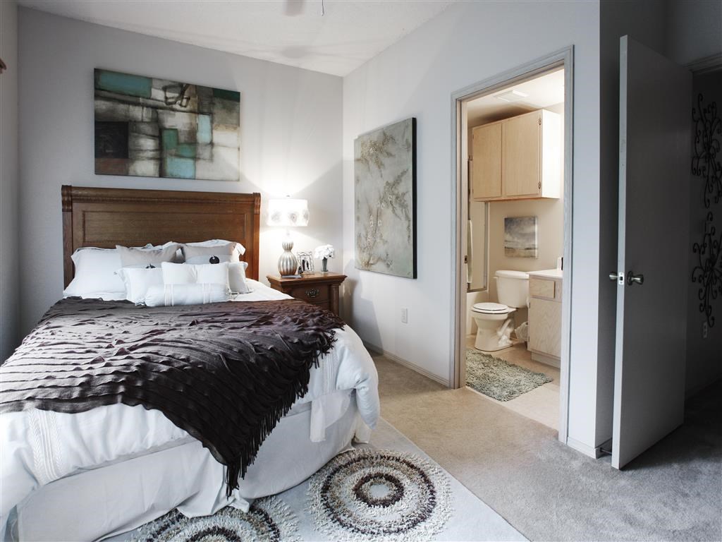 a bedroom with a bed and a bathroom with a toilet