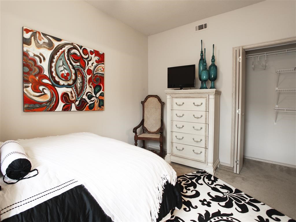 a bedroom with a bed and a dresser and a television