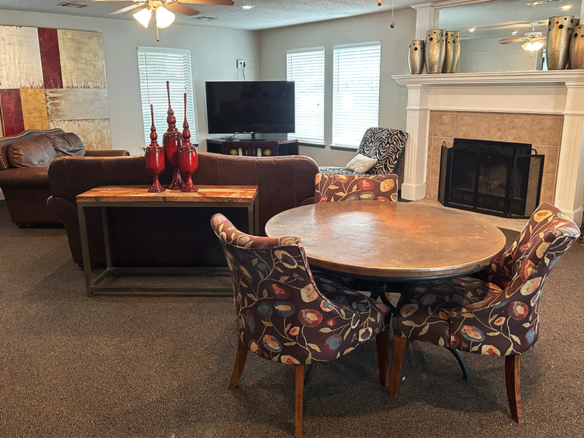 a living room with a table and chairs and a fireplace