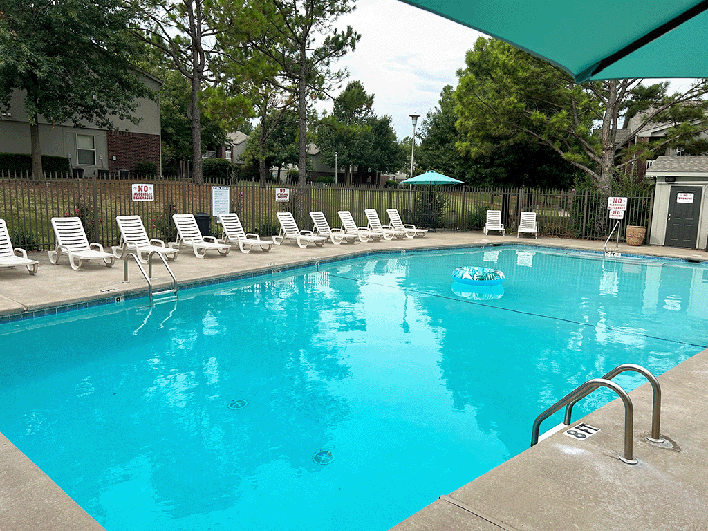 a swimming pool with chairs and a float in it