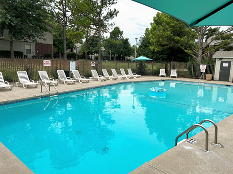 a swimming pool with chairs and a float in it