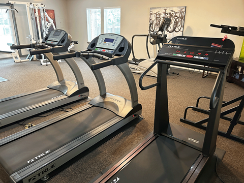 a gym with two treadmills and other exercise equipment