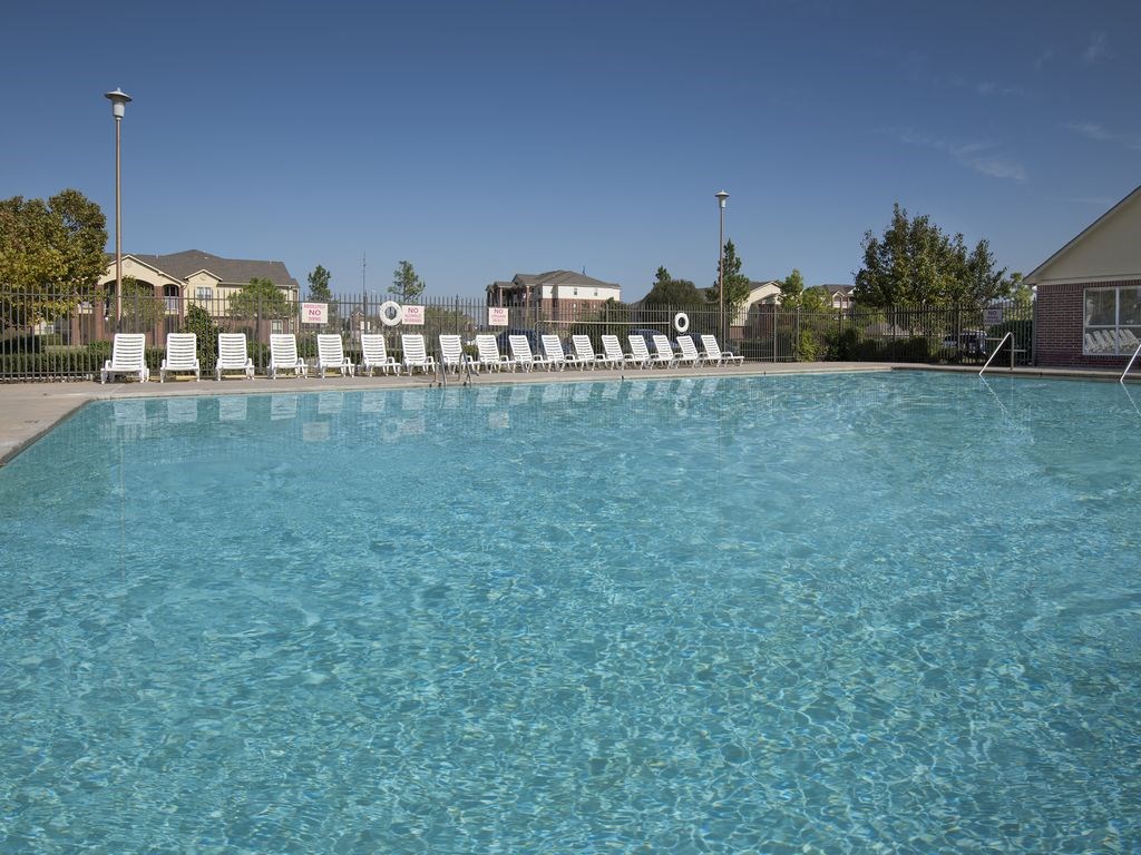 a large pool with white chairs on the side of it