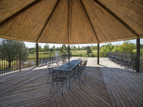a patio with a table and chairs under a roof