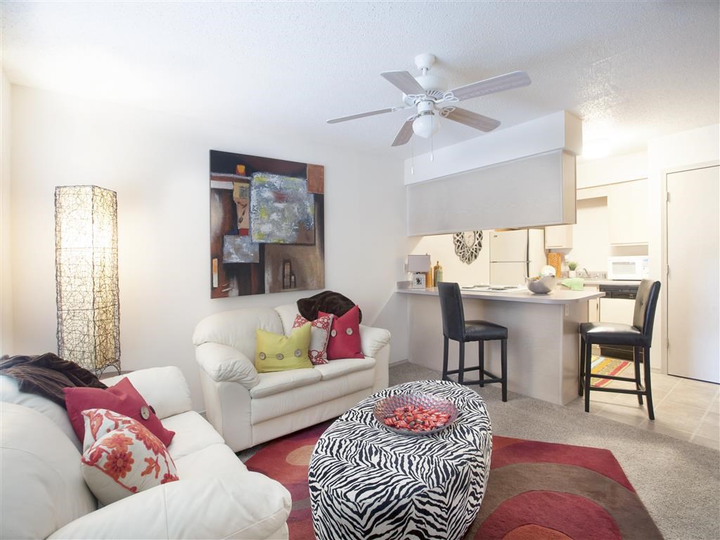 a living room with a couch and a ceiling fan