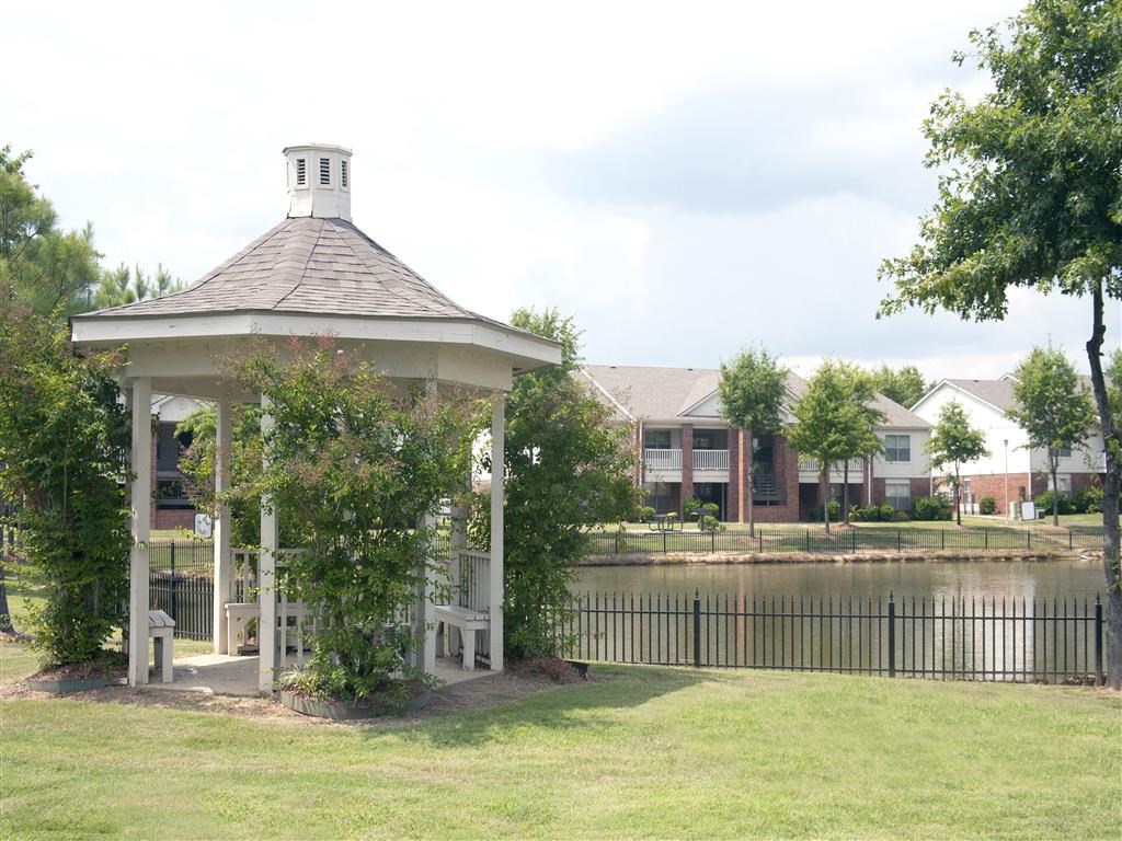 a gazebo with a pond in front of a building