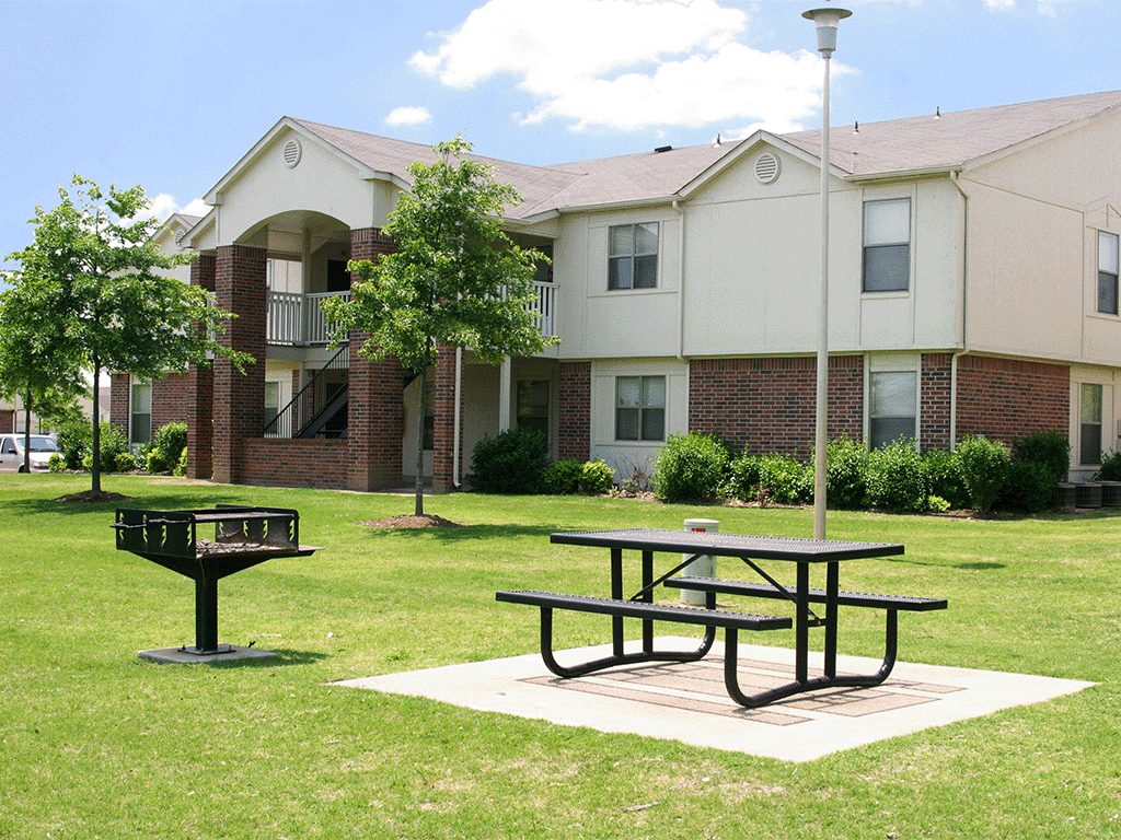 an outdoor picnic area in front of an apartment building