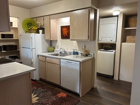 a kitchen with white appliances and a sink and a refrigerator