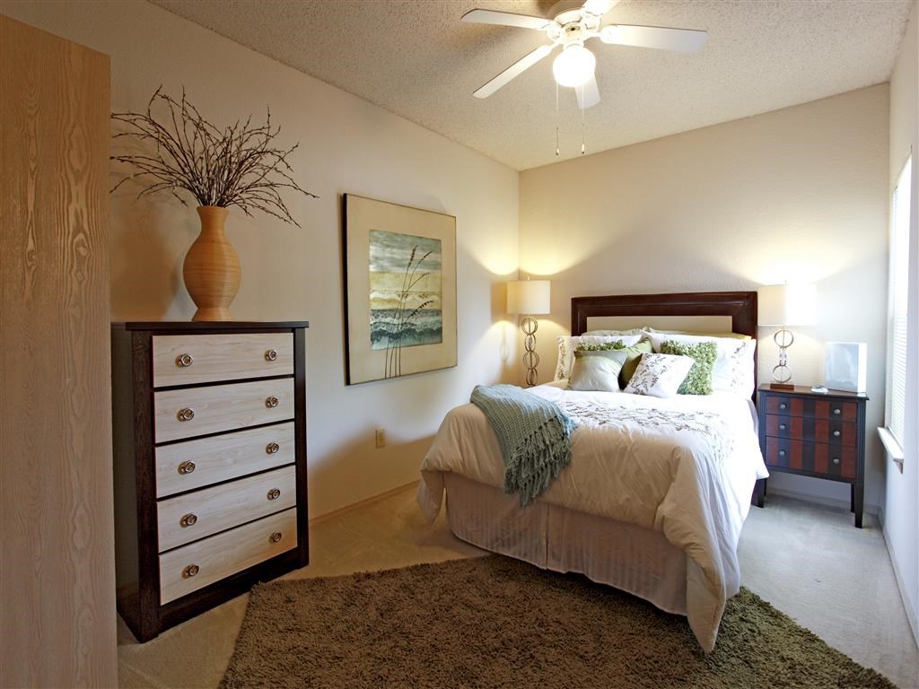 a bedroom with a bed and a ceiling fan