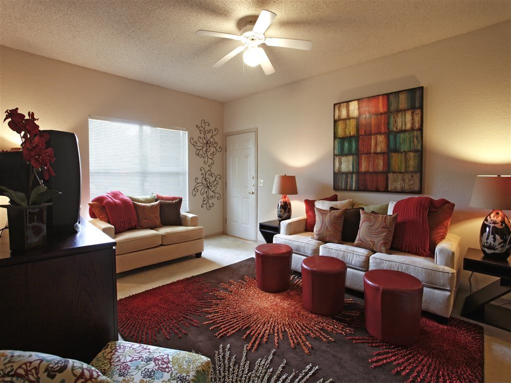 a living room filled with furniture and a ceiling fan