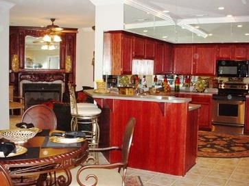 A kitchen with red cabinets and a fireplace.
