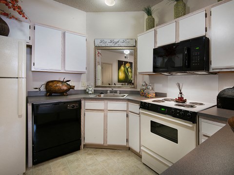 a kitchen with white cabinets and black appliances