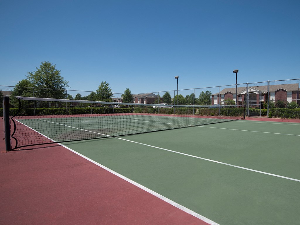 a tennis court with a net in the middle of a community