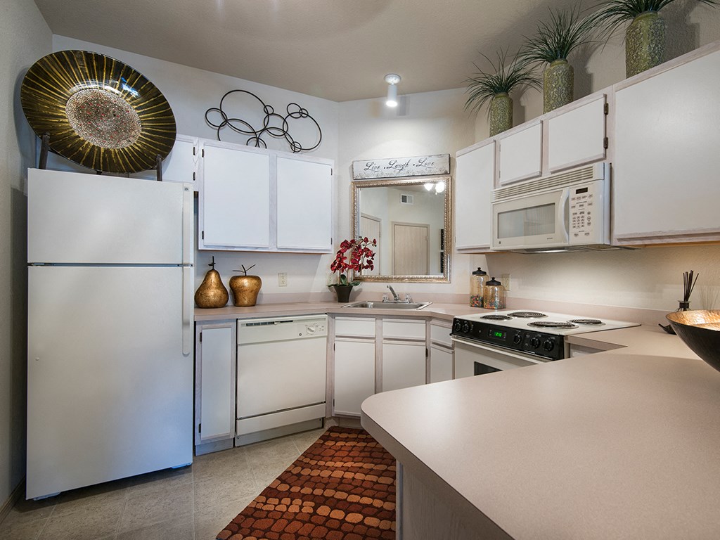 a kitchen with white cabinets and appliances and a counter top