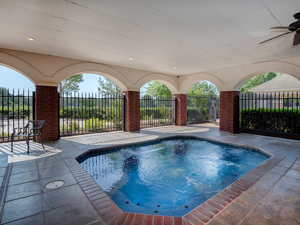 the pool is heated and has a fence around it to protect it from the sun