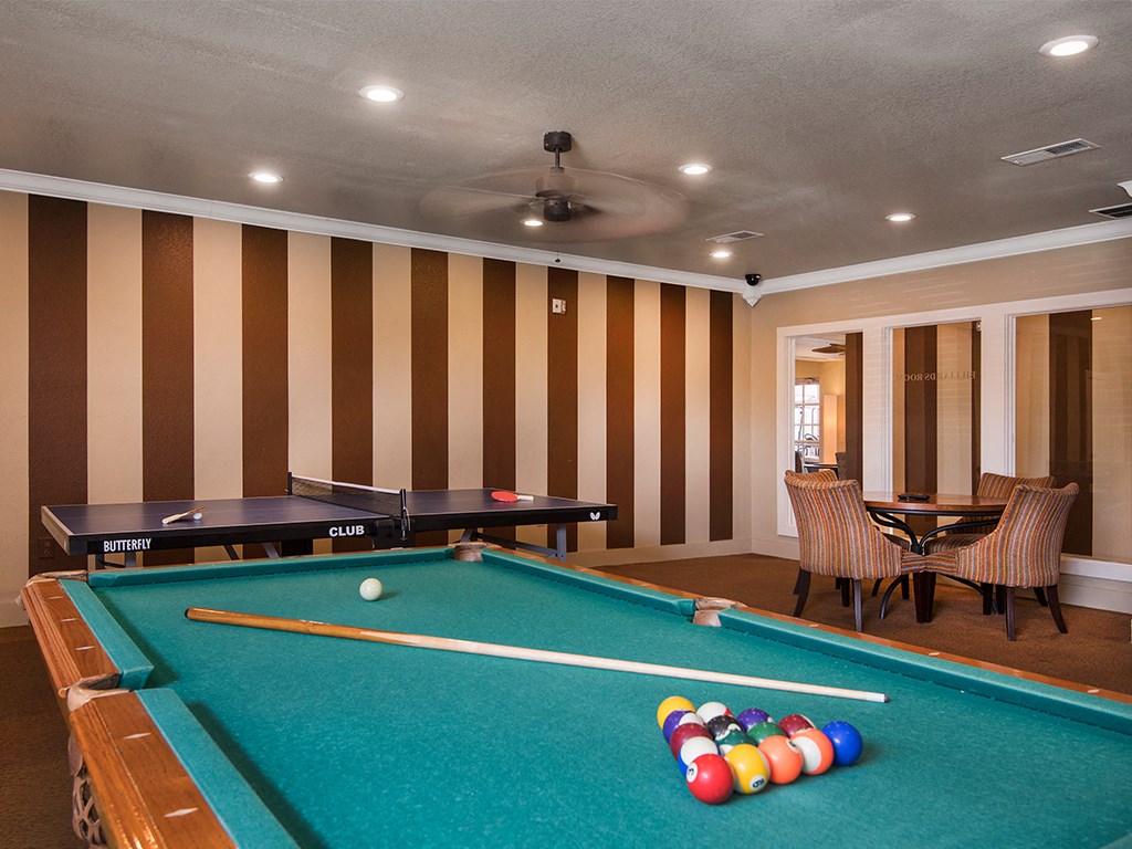 a game room with a pool table and tables